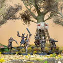 Miniature figures in a fantasy setting with a large tree and nest in the background